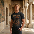 Man wearing an 'Iron Rain' t-shirt in a sunlit stone corridor.